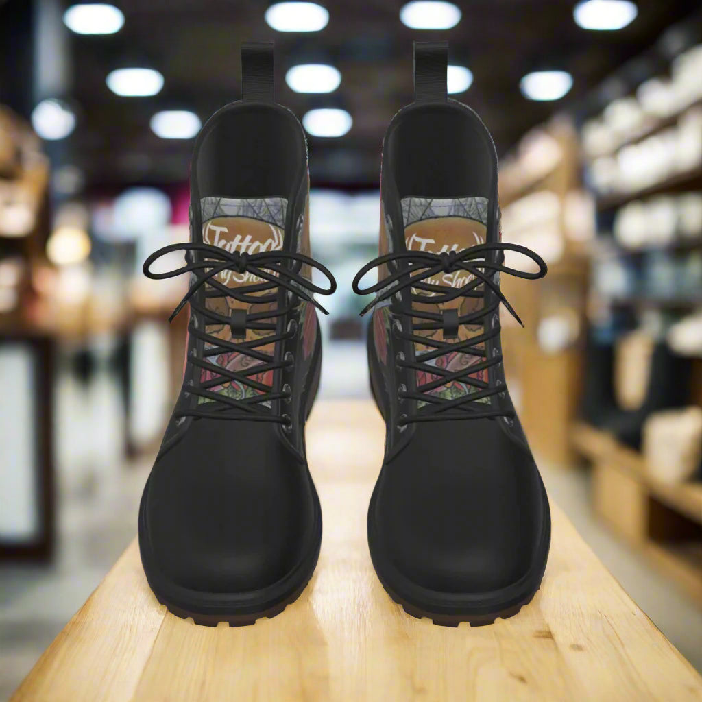 Pair of black boots with patterned insole on a white background