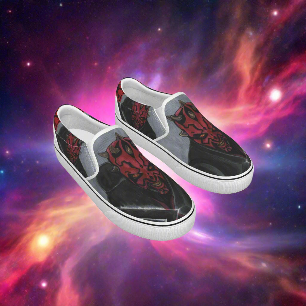Black slip-on shoes with red and white designs on a white background