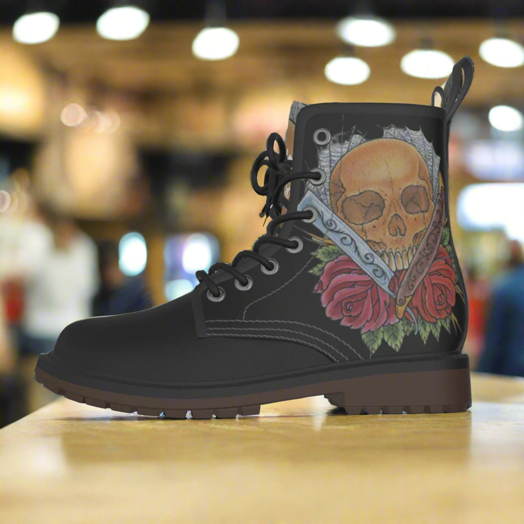 Black boot with skull and roses design on a white background