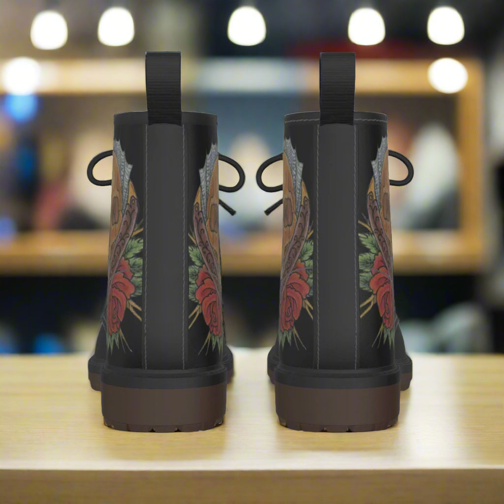 Black boots with floral designs on the sides against a white background