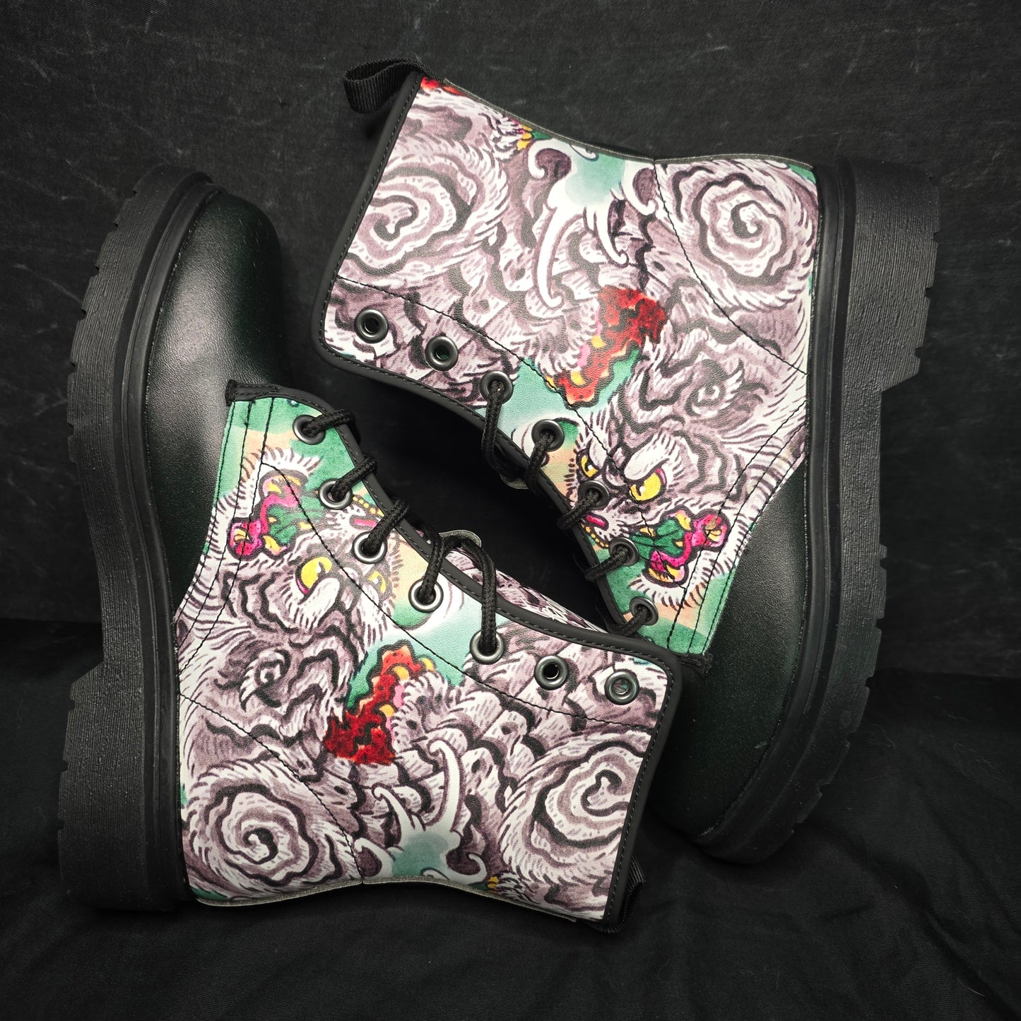 Black boots with colorful patterned soles on a dark background