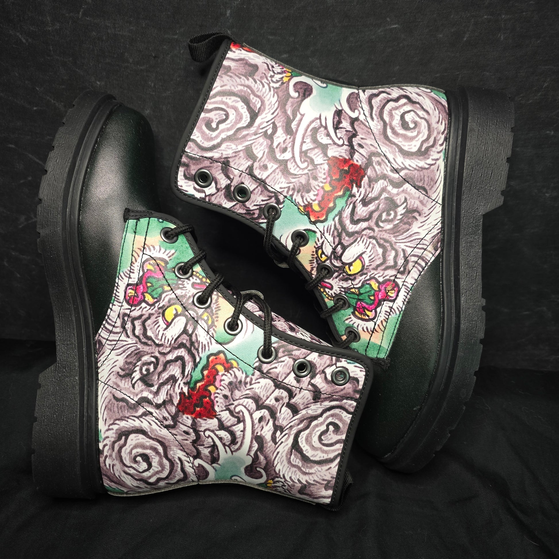 Black boots with colorful patterned soles on a dark background