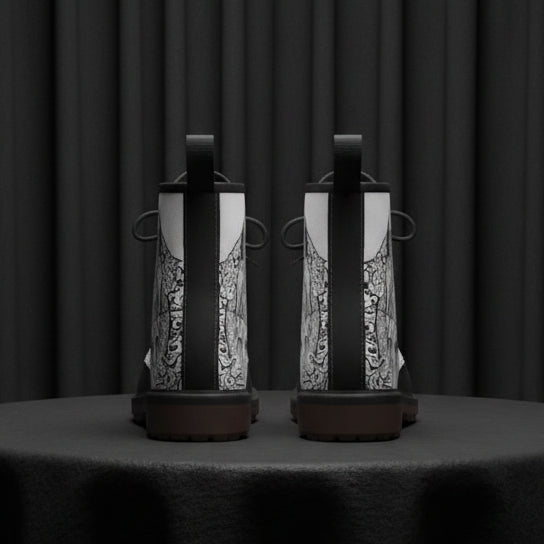 Pair of black and white boots with intricate patterns on a white background