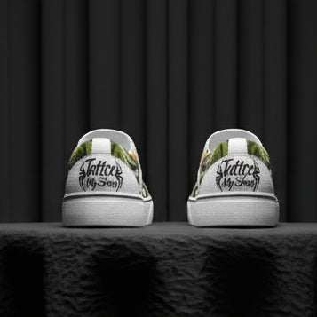 White sneakers with black text and green leaf patterns on a white background